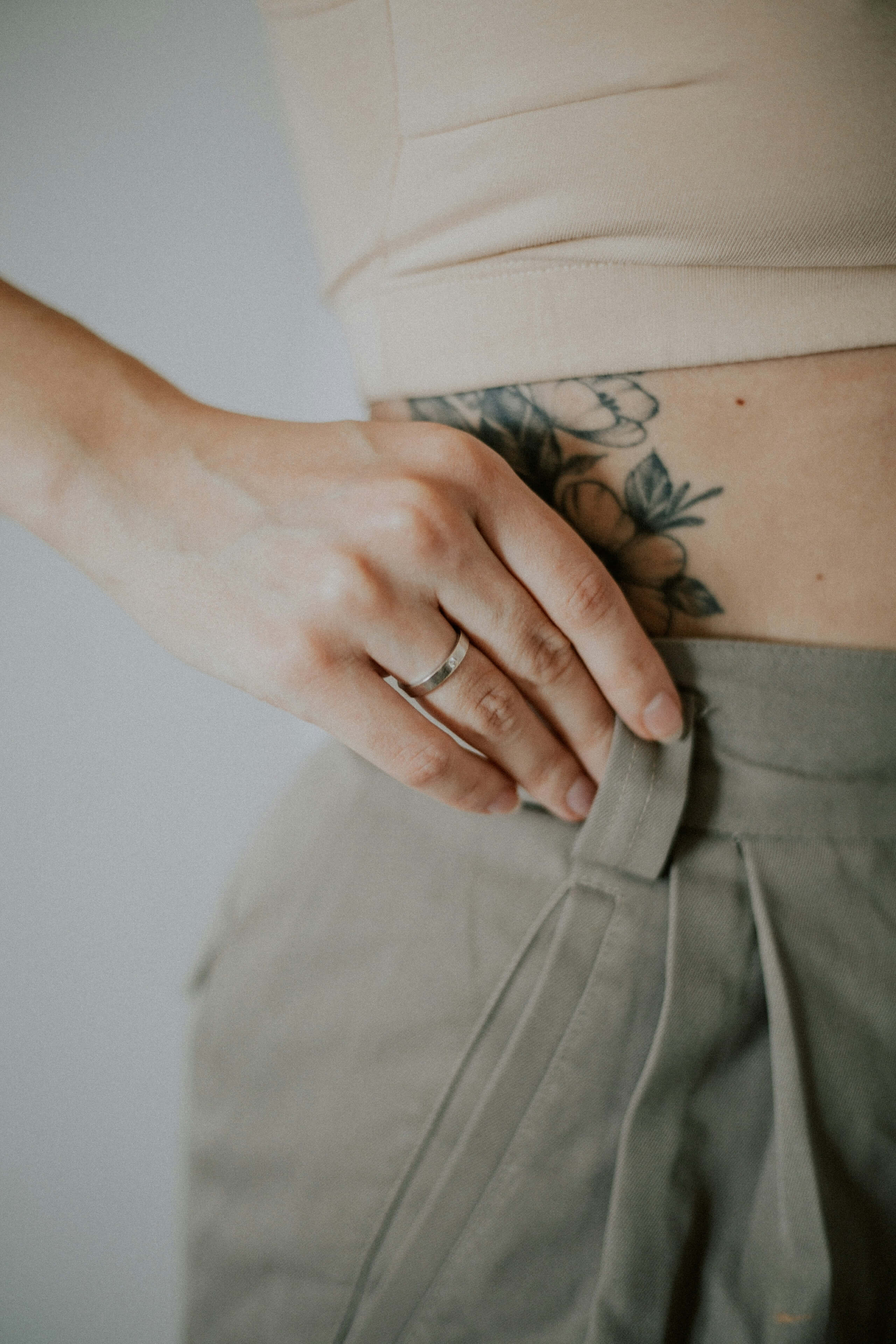 Die Taille einer Frau, auf ihrer Hüfte sieht man ein Tattoo